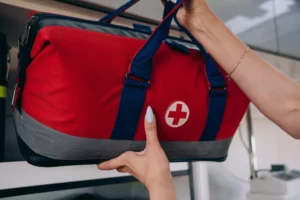mains qui portent un sac avec logos santé dans un casier d'avion au dessus des sièges passagers